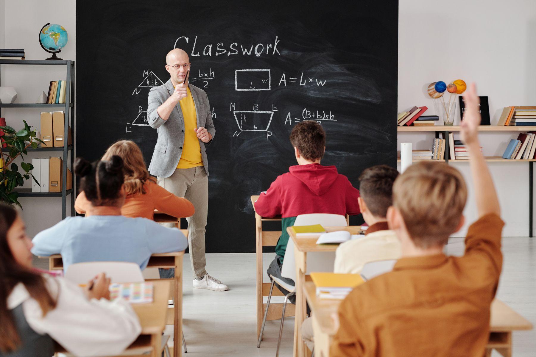 Schulklasse mit aufgestreckten Händen
